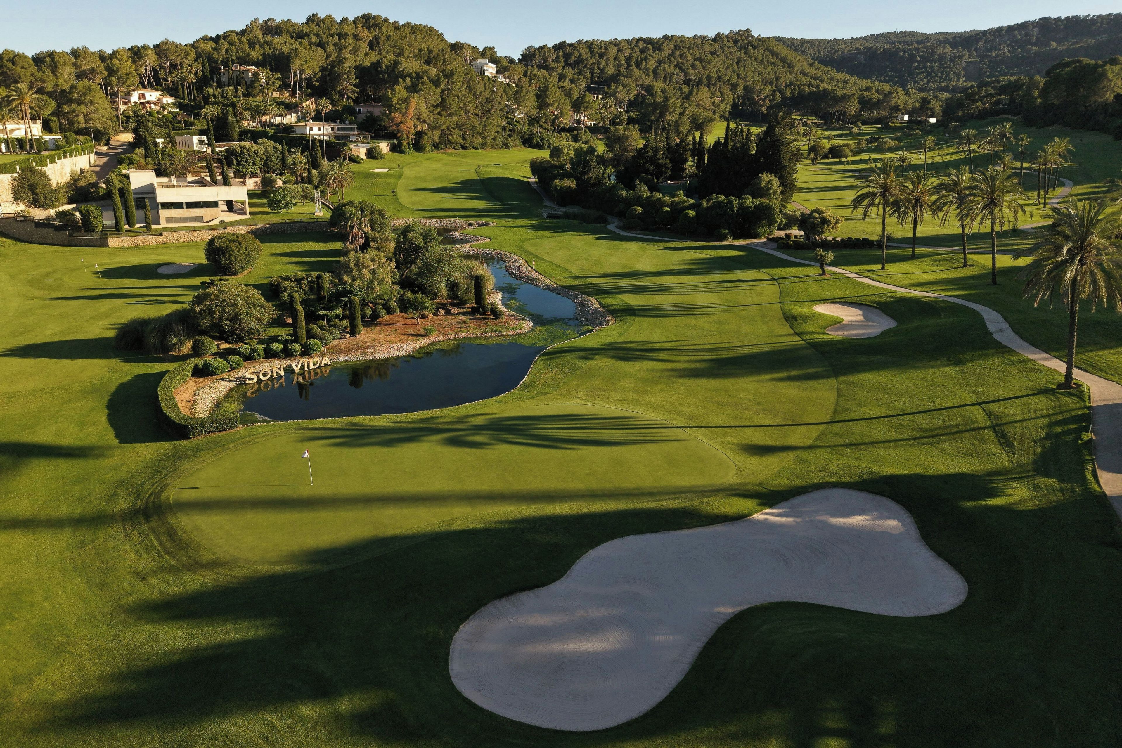 A golf course with sand bunkers, water hazards, and a pond.