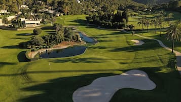 A golf course with sand bunkers, water hazards, and a pond.