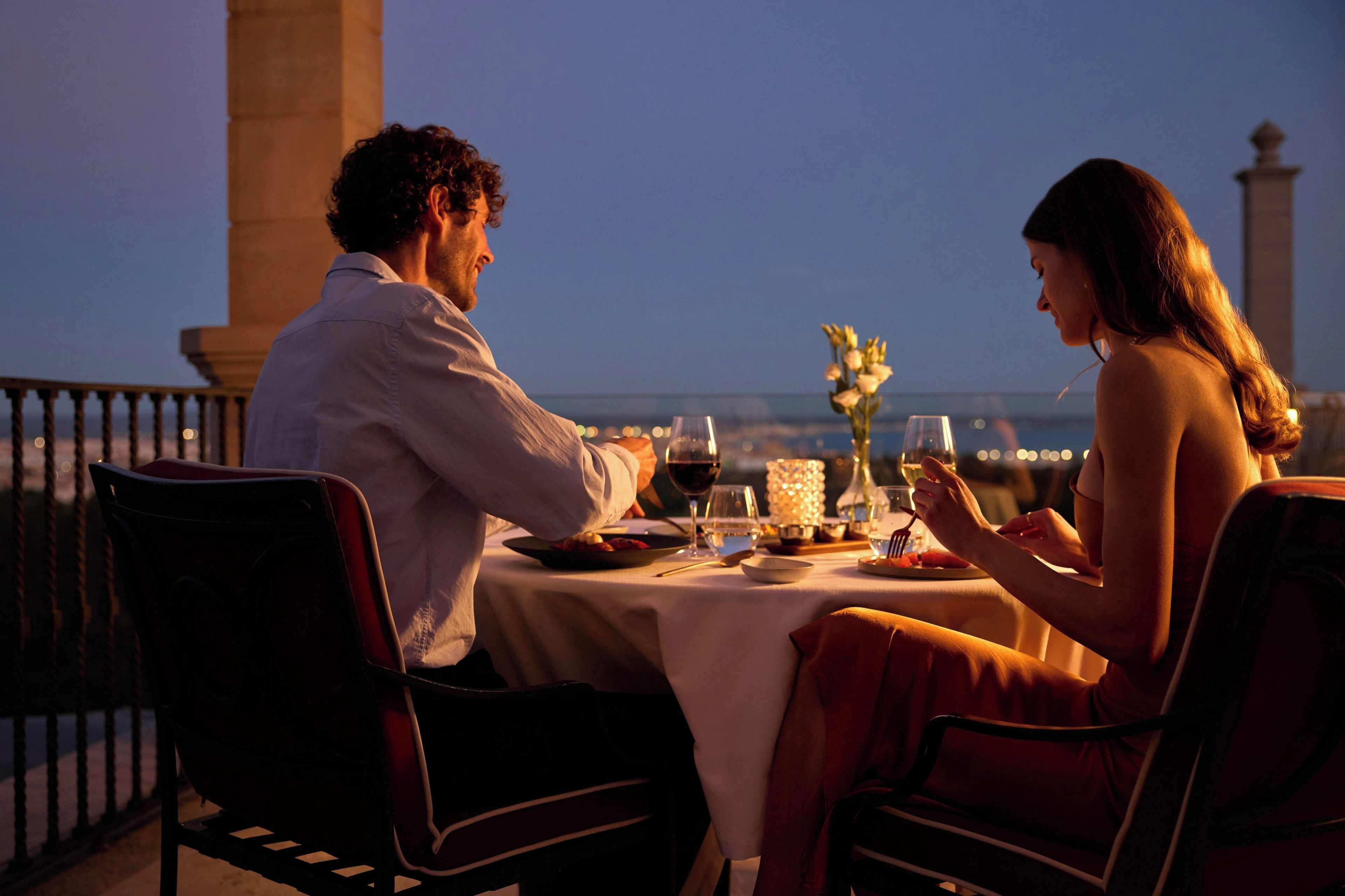 Een koppel dineert aan een tafel met uitzicht op de skyline.