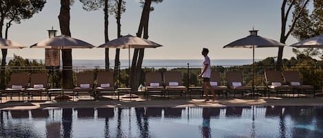 Piscine couverte, piscine extérieure, parasols de plage, chaises longues