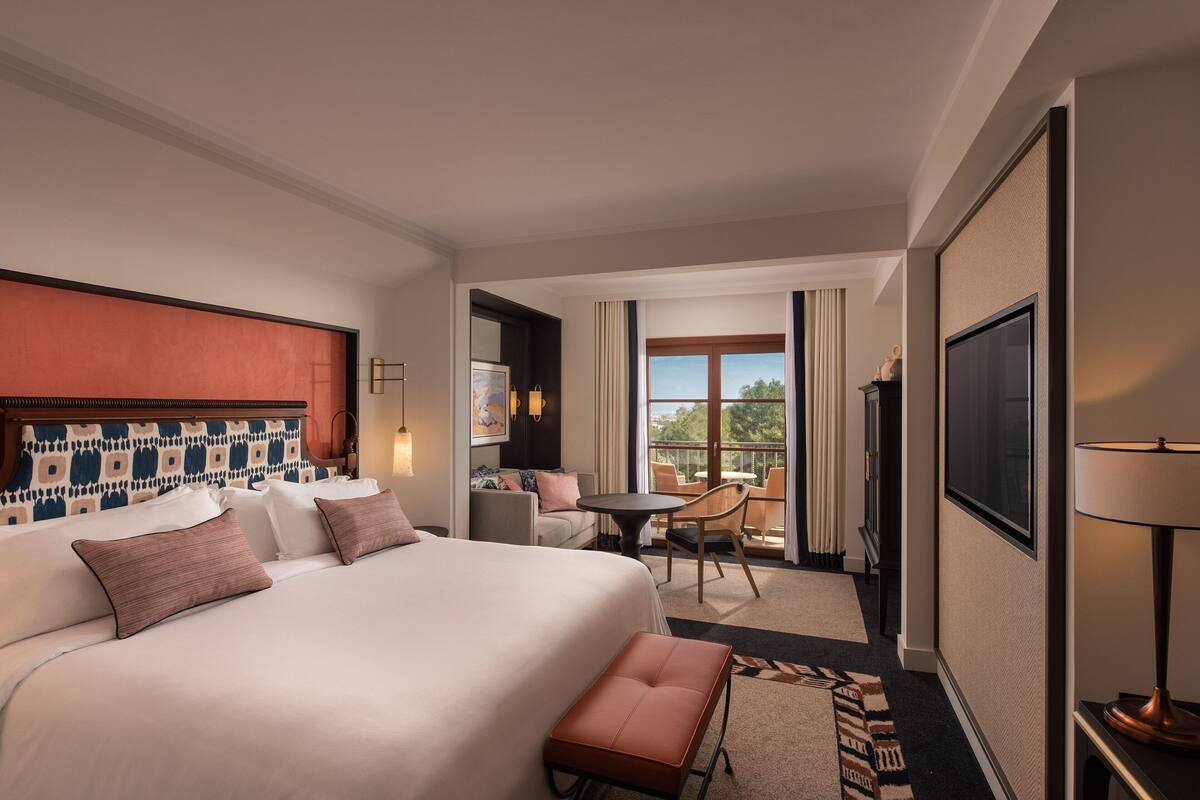 Une chambre d’hôtel avec un grand lit, une petite table, une chaise et une vue sur l’extérieur.