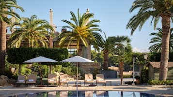 Una piscina cubierta, una piscina al aire libre, sombrillas, tumbonas