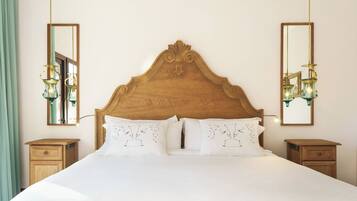 A bed with a wooden headboard, two bedside tables, and two wall-mounted lamps.