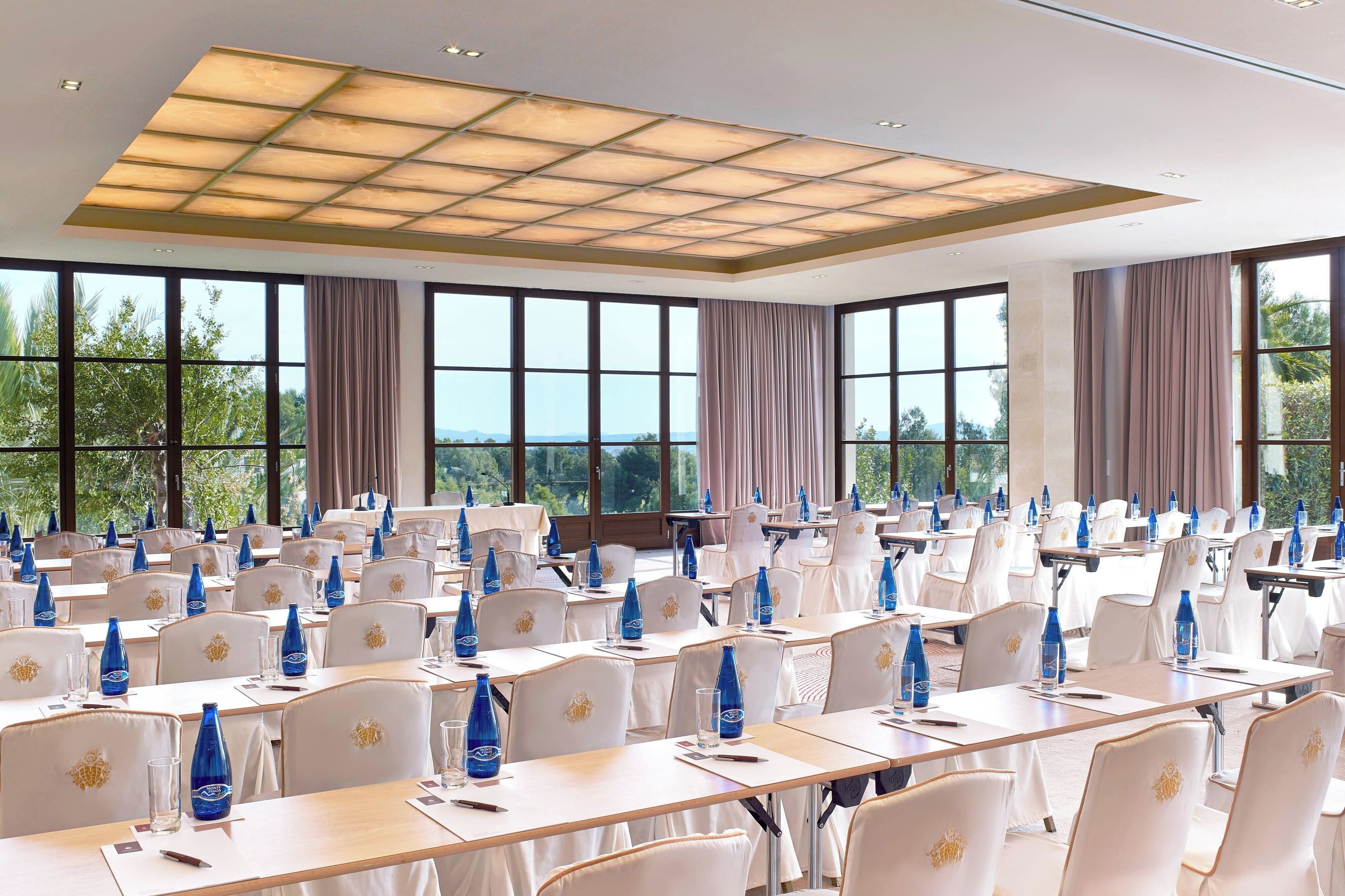 A conference room with tables, chairs, and water bottles.