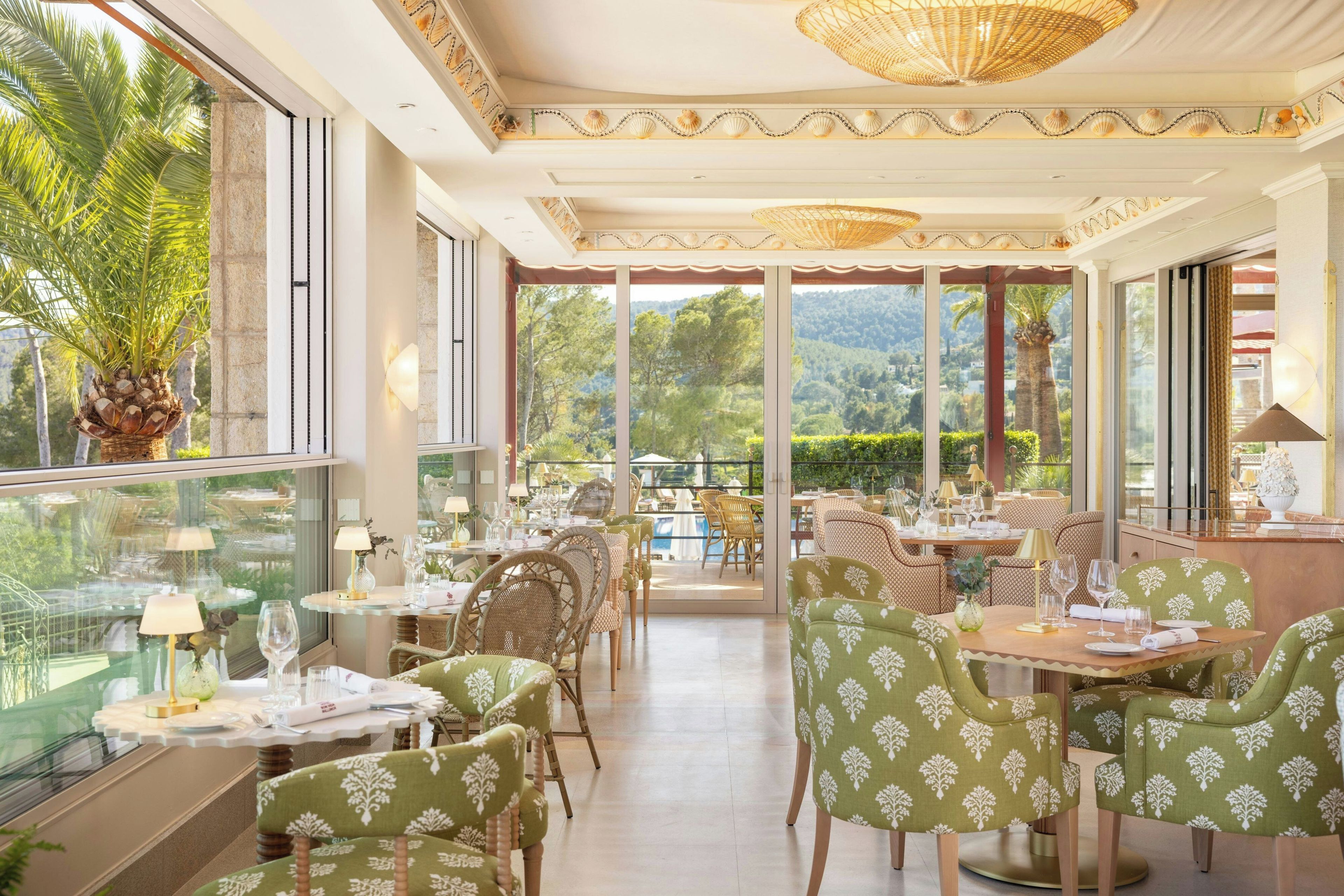 A restaurant with tables and chairs, large windows, and a view of the outdoors.