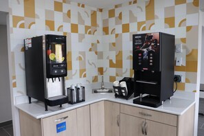 A coffee station with two espresso machines, a sink, and a recycling bin. - Days Inn by Wyndham La Crosse (La Crosse)
