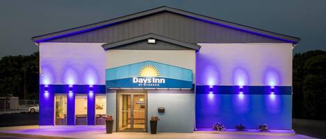 Edificio de Days Inn by Wyndham con cartel, entrada e iluminación exterior.