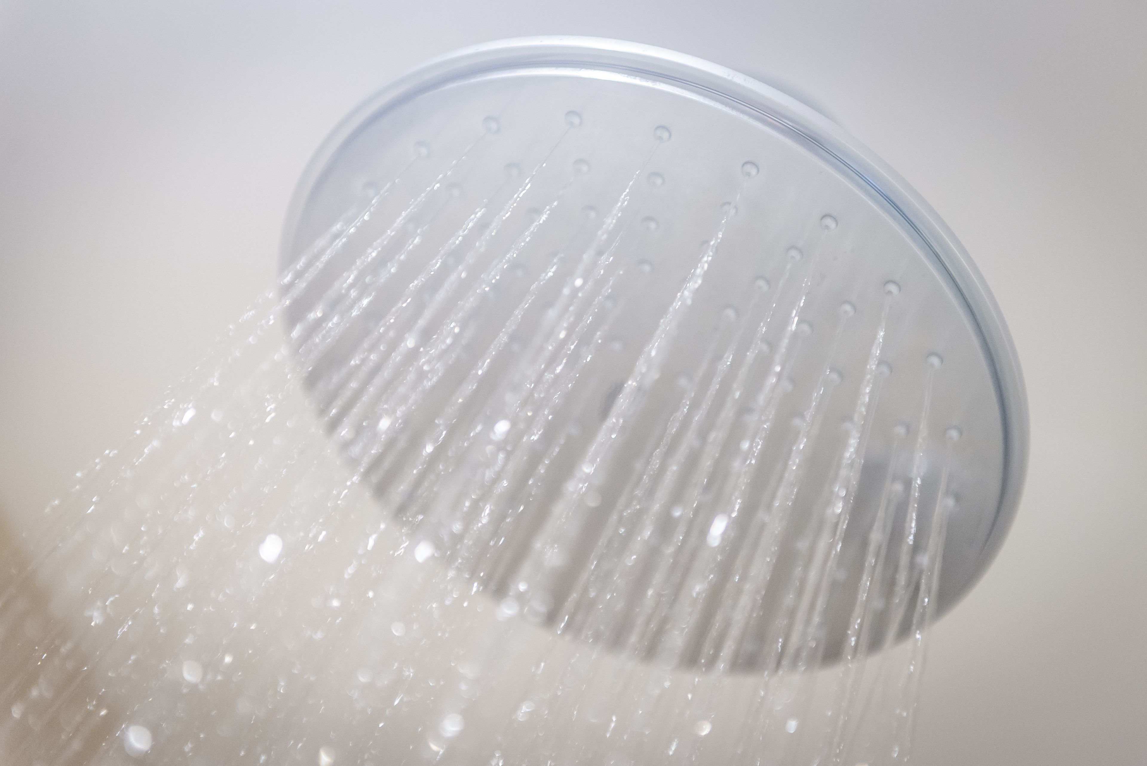 A showerhead with water flowing from it.