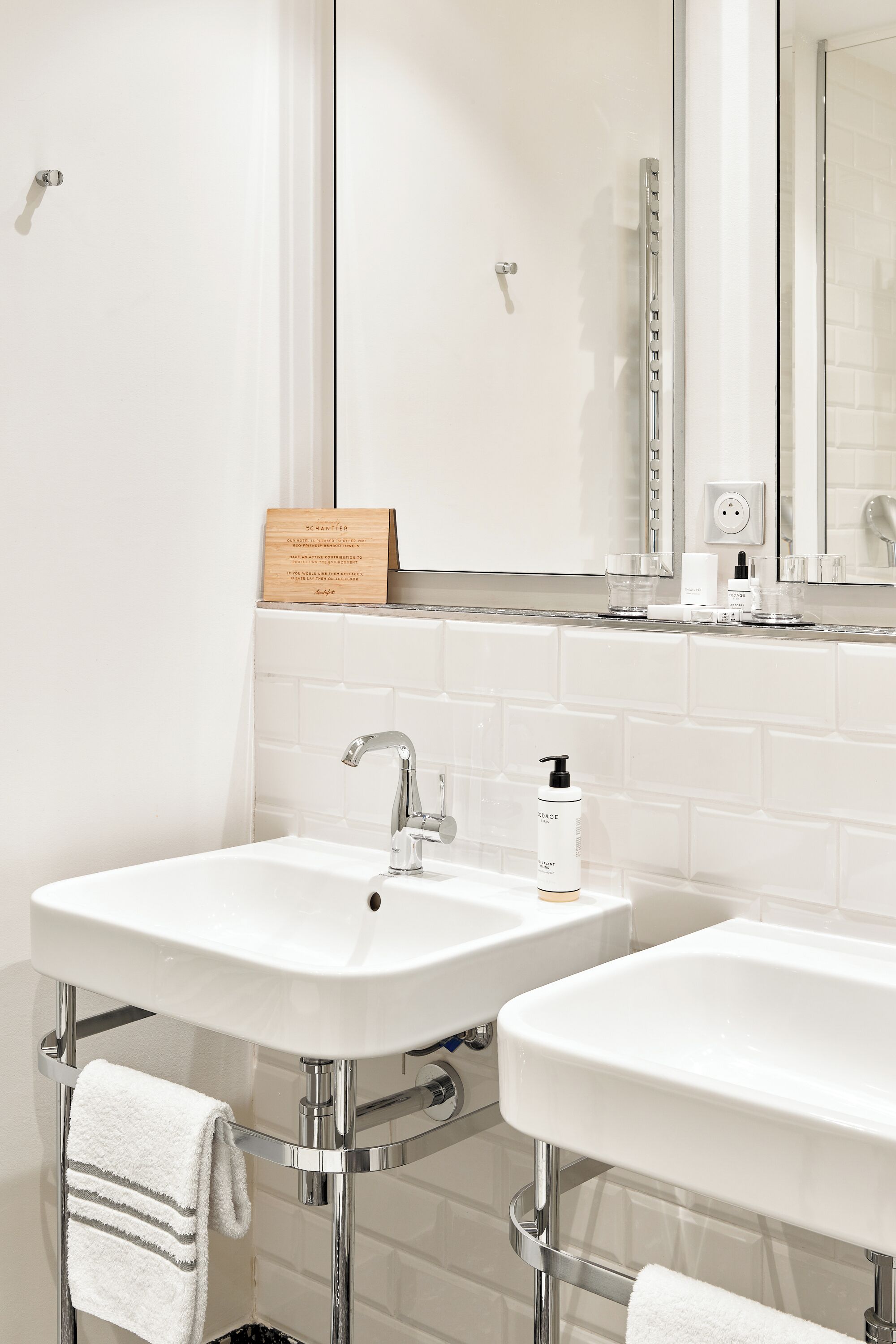 A bathroom with two sinks, chrome fixtures, and a mirror.