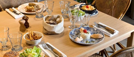 Una mesa de comedor servida con diversos platos, vasos y cubiertos.
