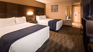 A hotel room with two beds, a nightstand, a mirror, and a television. - Best Western Andersen's Inn (Gustine)