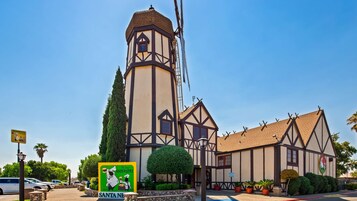 Un edificio de estilo Tudor con una torre destacada, un cartel de Santa Fe y un estacionamiento.