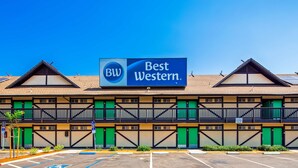 A Best Western hotel with a prominent sign, multiple green doors, and a parking lot. - Best Western Andersen's Inn (Gustine)