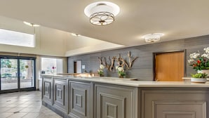 A modern kitchen with a large island, built-in cabinets, and decorative elements like branches and flowers. - Best Western Plus Monterey Inn (Monterey)