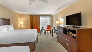 A hotel room with a bed, two chairs, a desk, a television, and a ceiling fan. - Best Western Plus Monterey Inn (Monterey)