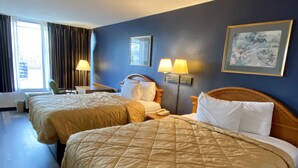 A hotel room with two beds, a desk, a chair, a lamp, and a painting on the wall. - Motel 6 Marianna, FL (Marianna)