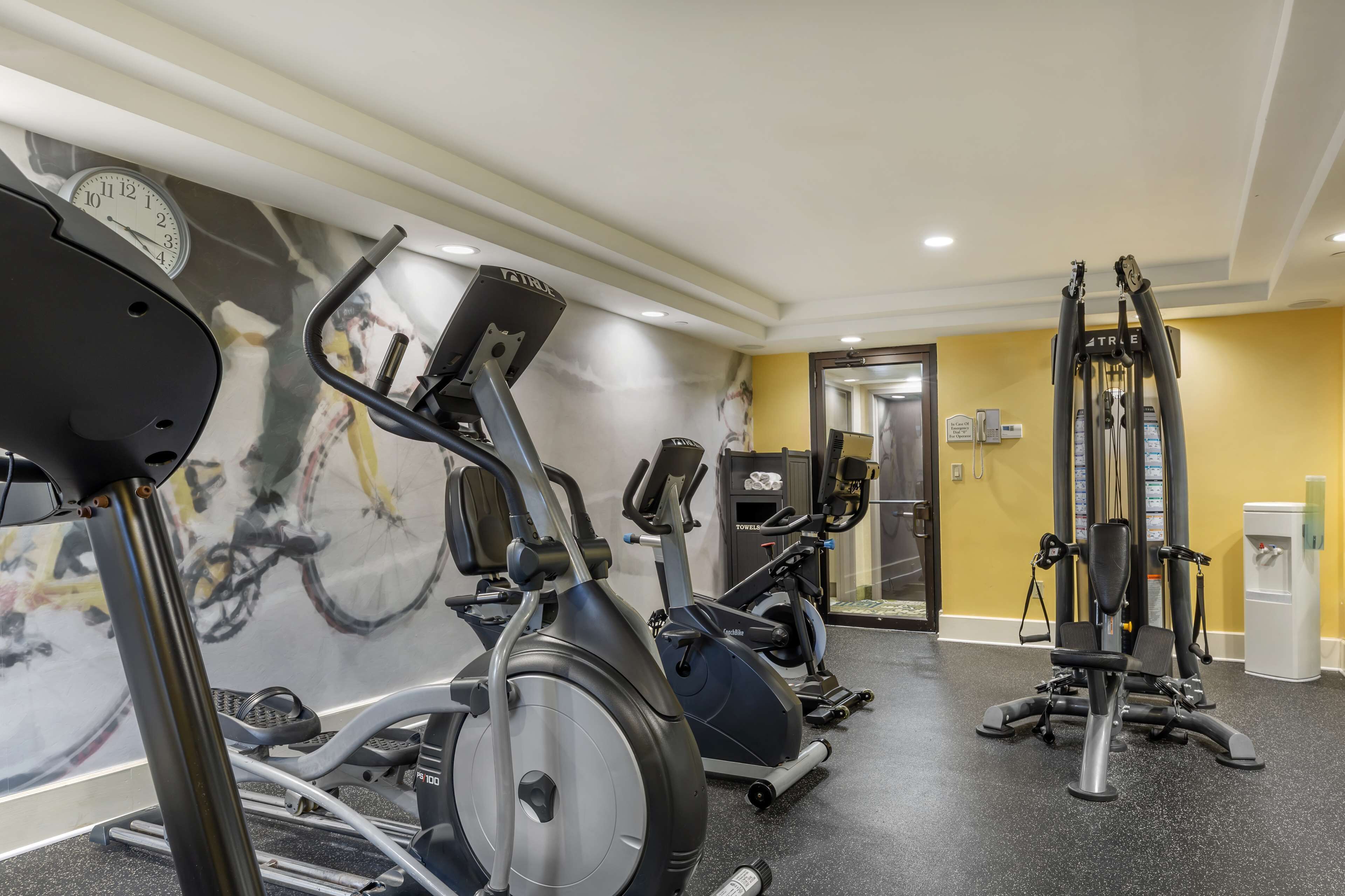 A gym with stationary bikes, elliptical machines, and weight machines.