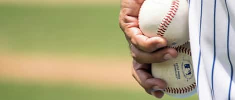 Une personne tenant une balle de baseball.