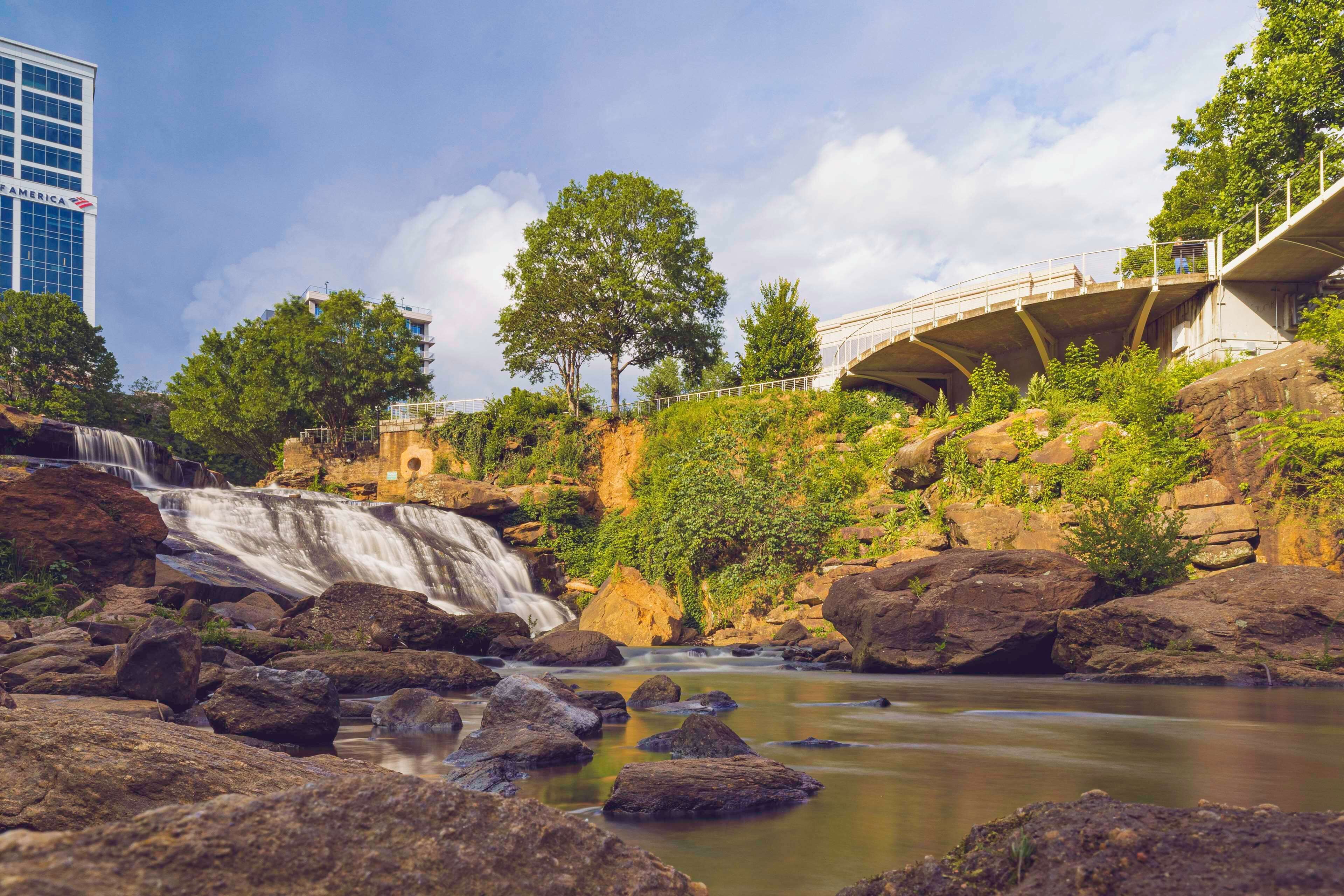 Une cascade, un terrain rocheux et un pont.