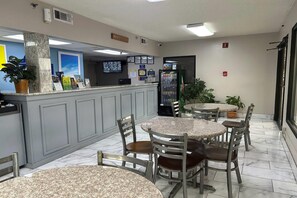 A restaurant with marble-topped tables and chairs, a registration desk, and a refrigerator. - Days Inn by Wyndham Dublin GA (Dublin)