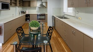 A modern kitchen with a central island, stainless steel appliances, and a potted plant.