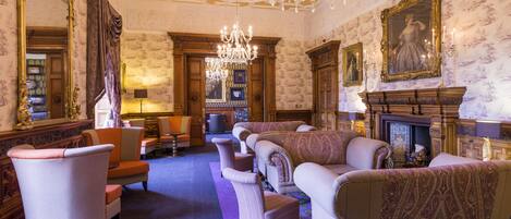 A luxurious room with ornate furniture, a grand chandelier, and a fireplace.