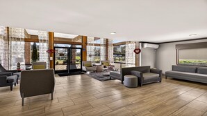 A spacious lobby with a modern design, featuring a mix of seating areas and a large glass door leading outside. - Best Western Amador Inn (Jackson)