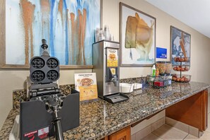 A breakfast bar with waffle batter dispensers, a waffle maker, and a sign for fresh waffles. - Best Western Amador Inn (Jackson)