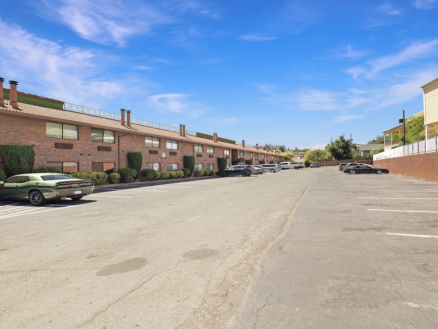 A row of brick buildings with a parking lot in front.