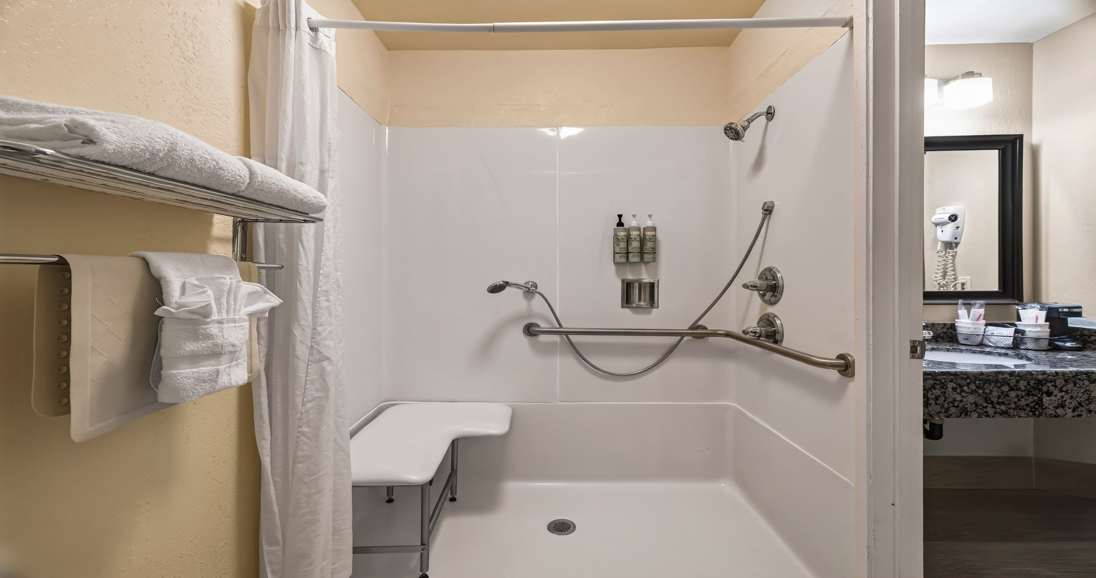 A bathroom with a shower, a towel rack, and a toilet.
