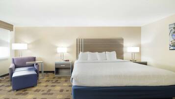 A hotel room with a large bed, two bedside tables, a chair, and a wall-mounted artwork.