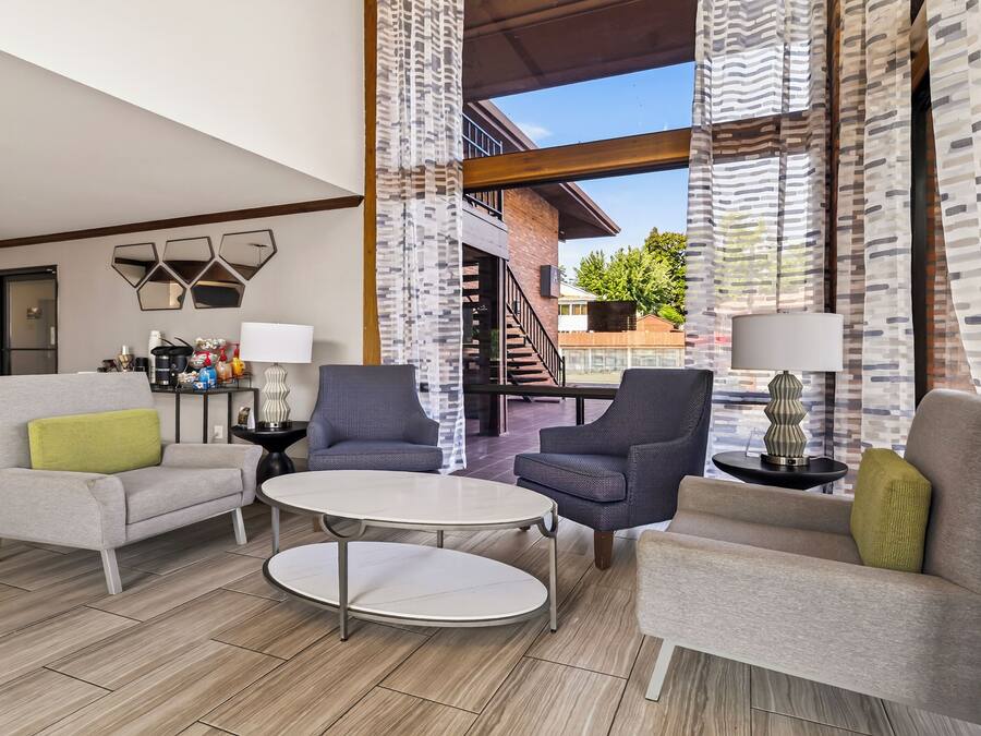 A modern living room with a round table, two sofas, and a coffee table.