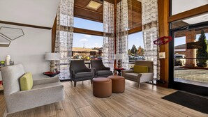 A modern lobby with a seating area, large windows, and a view of the outside. - Best Western Amador Inn (Jackson)
