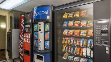Una máquina expendedora con logotipo de Pepsi, una máquina expendedora de Coca-Cola y otra máquina expendedora de snacks.