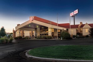 A Red Roof Inn with a gas station attached, featuring a large parking lot and a well-maintained lawn. - Red Roof Inn & Suites Cincinnati North - Mason (Cincinnati)