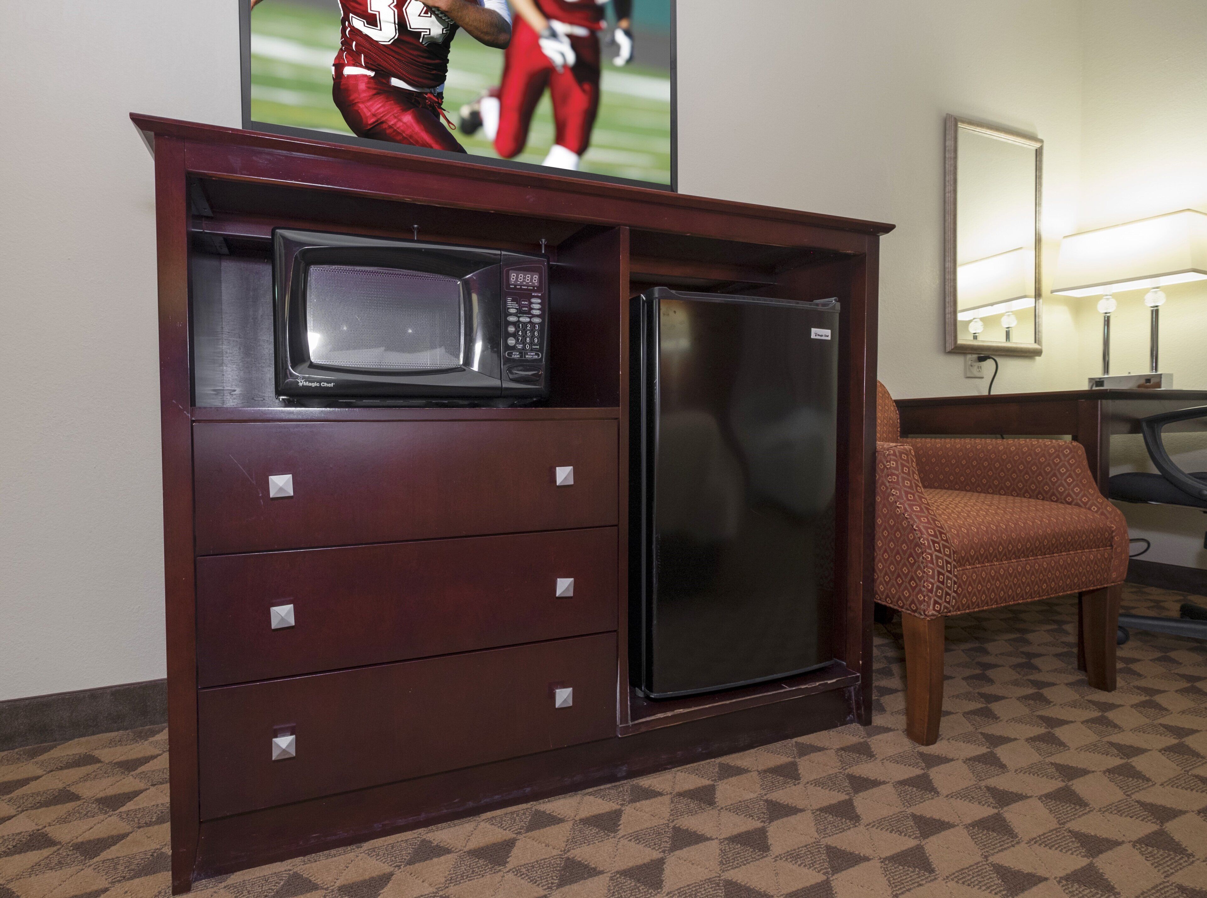Habitación de hotel con minibar, televisor y zona de estar.