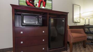 Habitación de hotel con minibar, televisor y zona de estar.