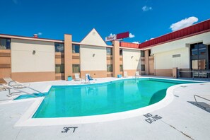 A swimming pool with a 'No Diving' sign, lounge chairs, and a building with a 'Red Roof' sign. - Red Roof Inn & Suites Cincinnati North - Mason (Cincinnati)