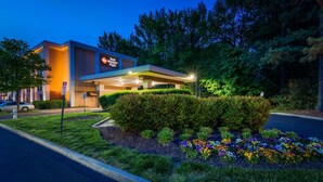 A hotel with a modern design, a parking sign, and a landscaped garden with colorful flowers. - Best Western Plus Richmond Airport Hotel (Sandston)