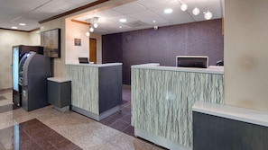 A reception area with a counter, a cash register, and a security camera.
