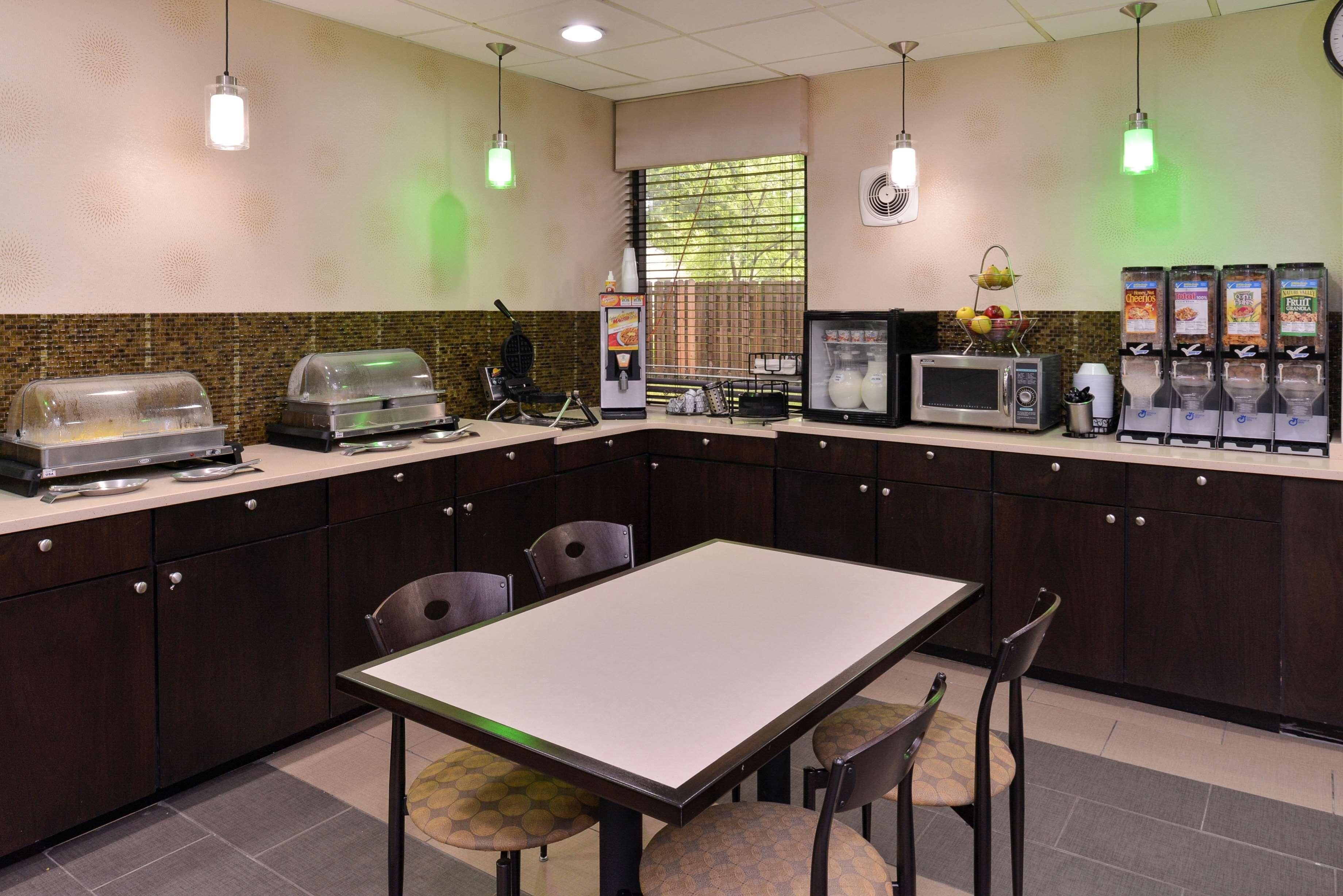 A restaurant with a buffet setup, a microwave, and a refrigerator.