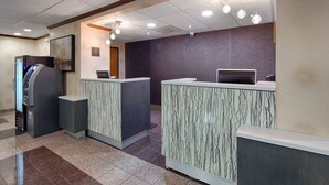 A reception area with a counter, a self-service kiosk, and a wall-mounted security camera. - Best Western Plus Richmond Airport Hotel (Sandston)