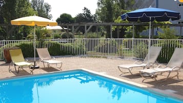 Een seizoensgebonden buitenzwembad, parasols voor strand/zwembad