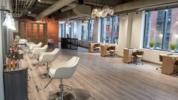 Un salon moderne doté de plusieurs espaces de détente, de grandes fenêtres et d’un design épuré de style industriel.