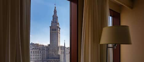 Una habitación con un amplio ventanal que ofrece vistas de un edificio histórico con una torre alta.