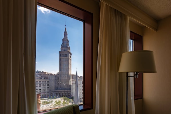 A room with a large window offering a view of a historic building with a tall tower.