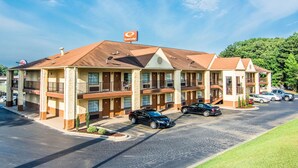 A motel with a brown roof and beige walls, featuring a sign for Econo Lodge. - Econo Lodge Jasper (Jasper)
