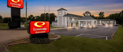 Entrada del EconoLodge, con un estacionamiento y un edificio al fondo.