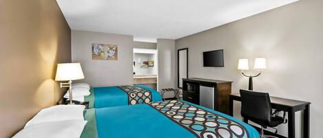 A hotel room with two beds, a desk, a chair, a TV, and a lamp.