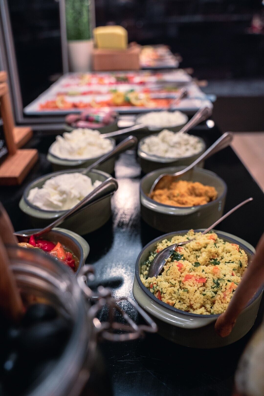 A buffet with various dishes, including couscous, rice, and a vegetable dish.